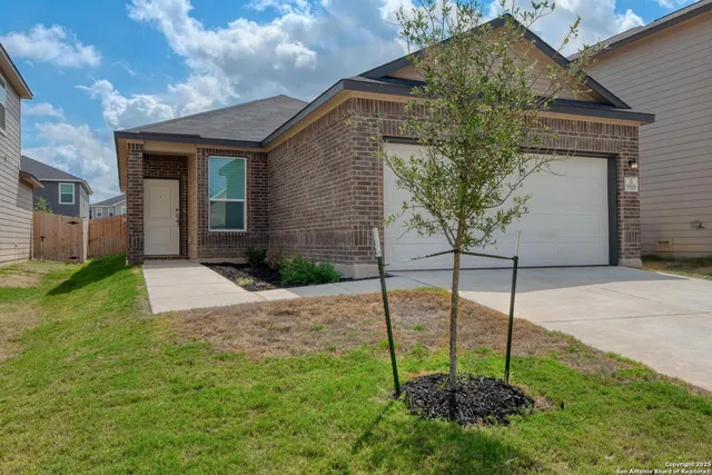 a backyard of a house with plants and outdoor seating