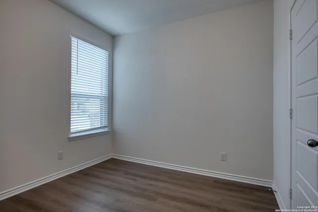 an empty room with wooden floor and a window