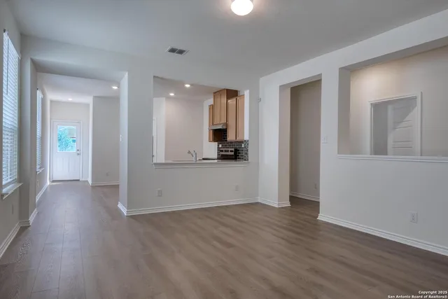 an empty room with wooden floor and mirror