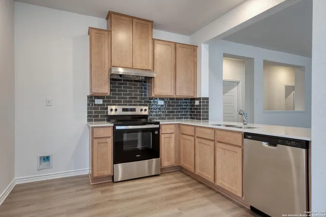 a kitchen with stainless steel appliances granite countertop a stove and a sink