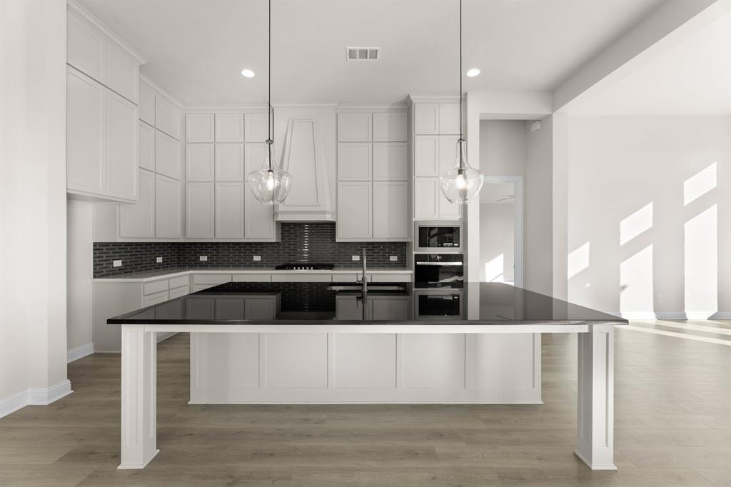 4802 Timberdrift Street Midlothian, TX 76065 - Photo 21 of 34 a large kitchen with stainless steel appliances granite countertop a sink a stove and a refrigerator