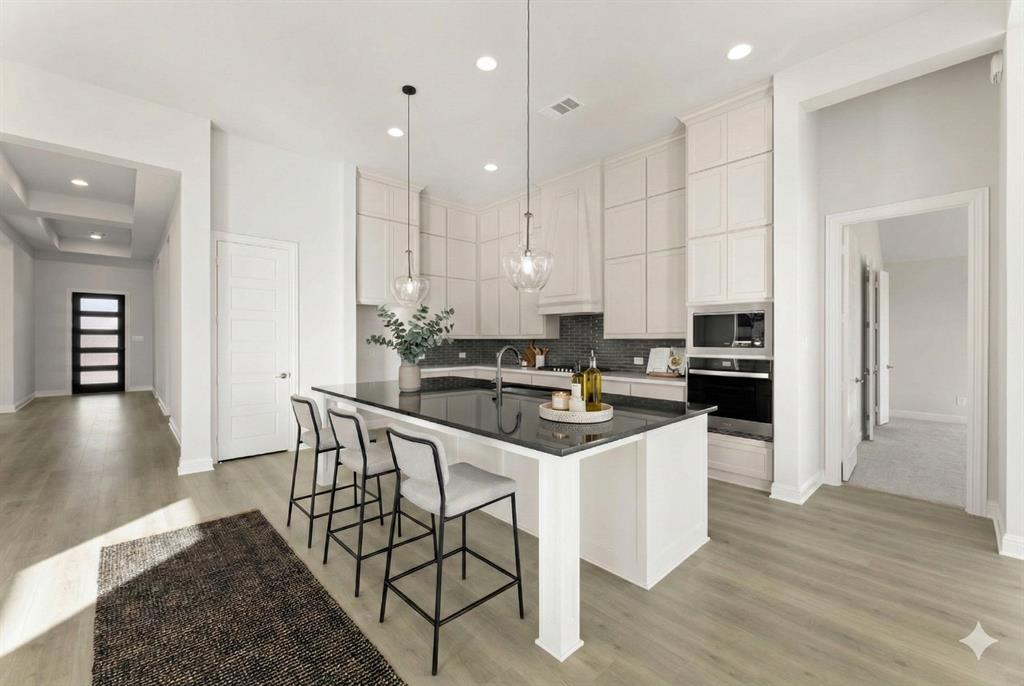 4802 Timberdrift Street Midlothian, TX 76065 - Photo 22 of 34 a kitchen with a sink a center island stainless steel appliances and cabinets