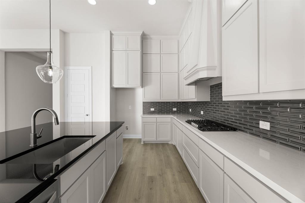 4802 Timberdrift Street Midlothian, TX 76065 - Photo 25 of 34 a kitchen with stainless steel appliances granite countertop a sink a stove and white cabinets