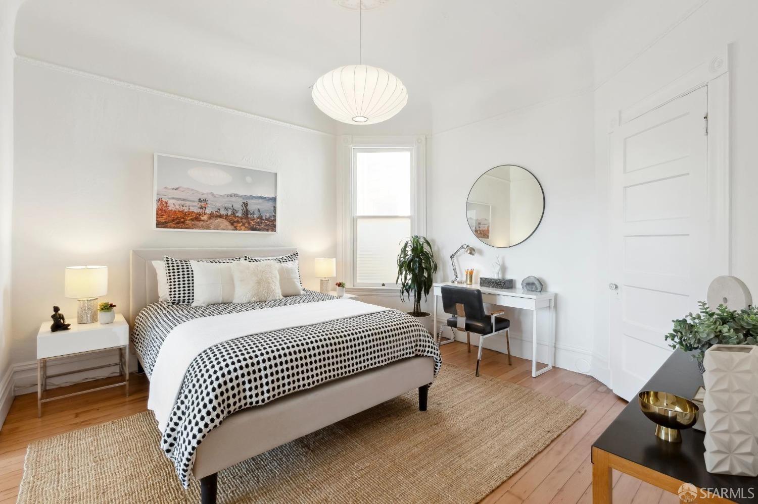 3270 20th Street San Francisco, CA 94110 - Photo 18 of 32 a bed room with a bed mirror and a chandelier