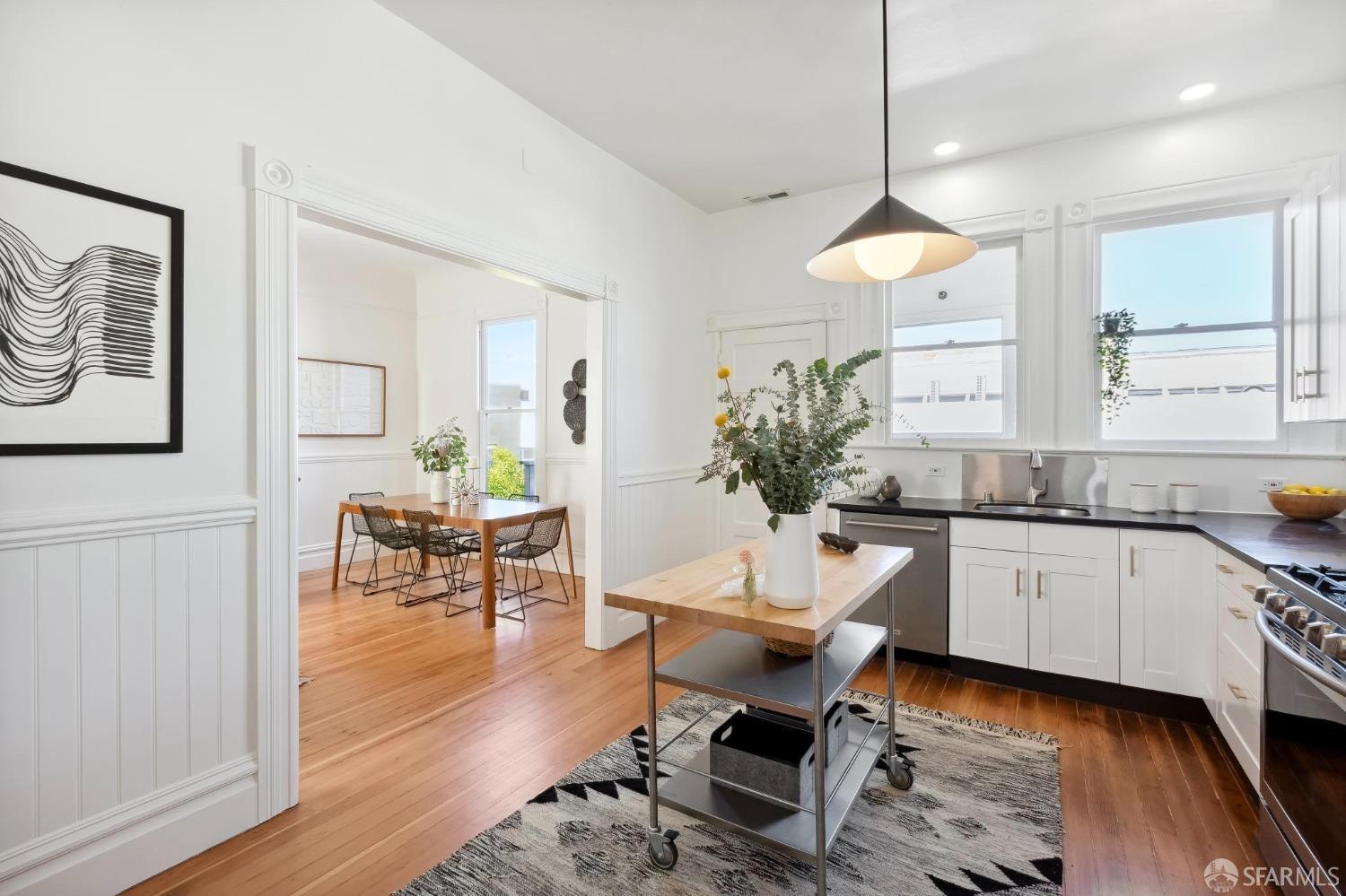 3270 20th Street San Francisco, CA 94110 - Photo 7 of 32 a kitchen with a dining table chairs wooden floor and a window