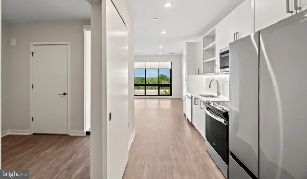 a kitchen with stainless steel appliances granite countertop a window a sink and a refrigerator