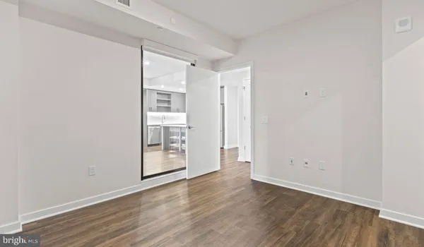 a kitchen with stainless steel appliances granite countertop a refrigerator a stove top oven a dining table and chairs with wooden floor