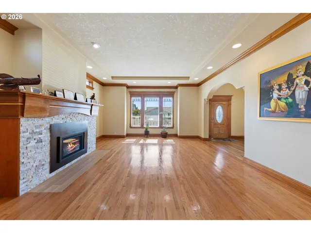 a view of an empty room with a fireplace and a window