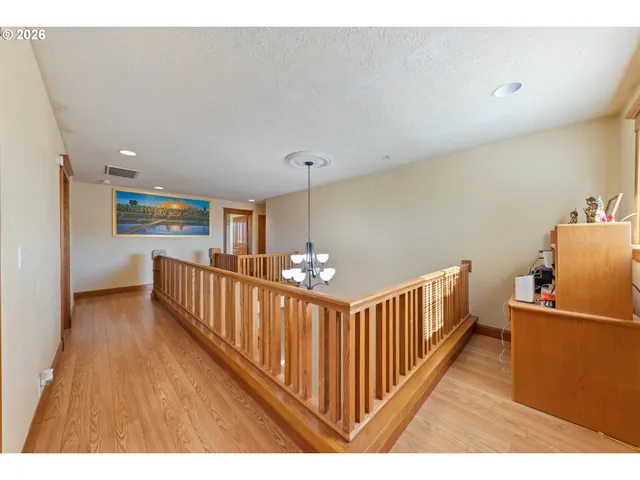a view of a hallway with an entryway and wooden floor