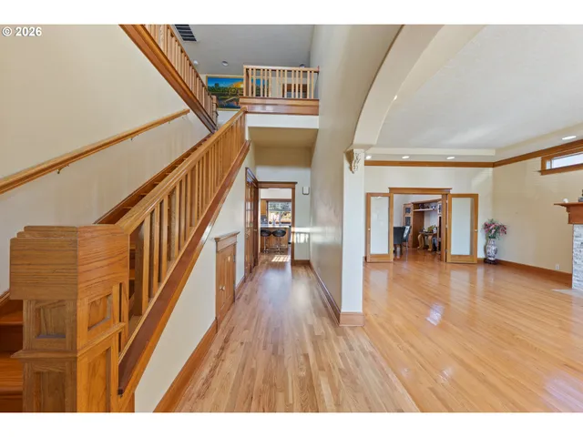 a view of a hallway with wooden floor and staircase