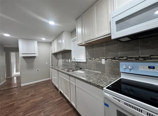 a kitchen with stainless steel appliances granite countertop a sink and a stove