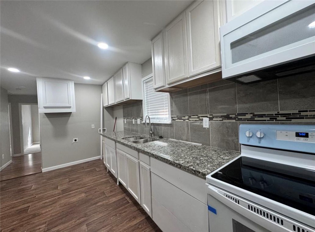 4603 Castle Avenue Bryan, TX 77808 - Photo 2 of 8 a kitchen with stainless steel appliances granite countertop a sink and a stove