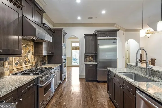a kitchen with stainless steel appliances granite countertop a sink stove and refrigerator