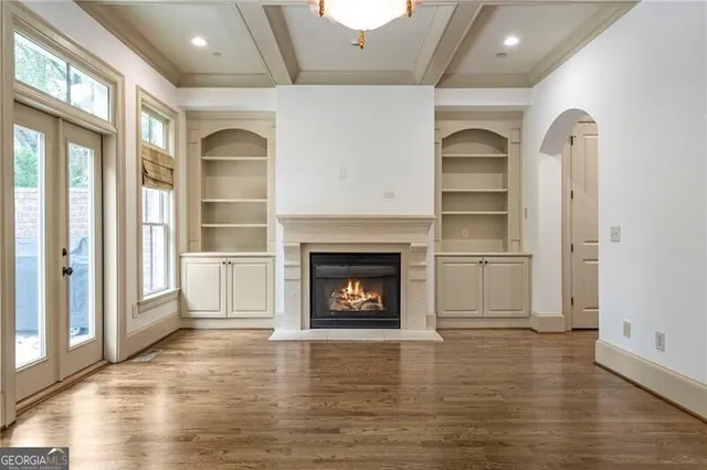 a view of a livingroom with wooden floor and a fireplace