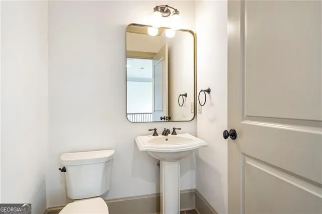 a bathroom with a sink mirror and toilet
