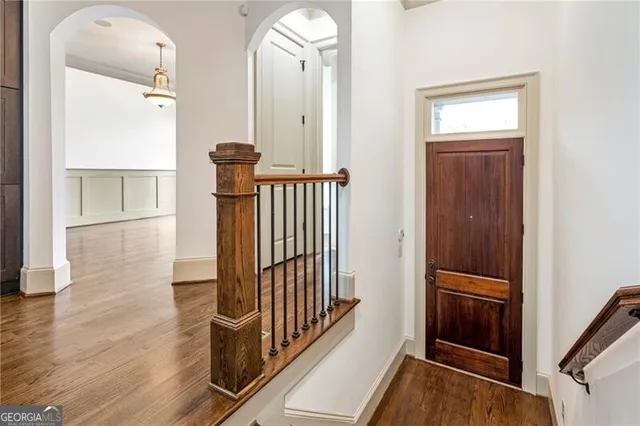 a view of a hallway with wooden floor and staircase