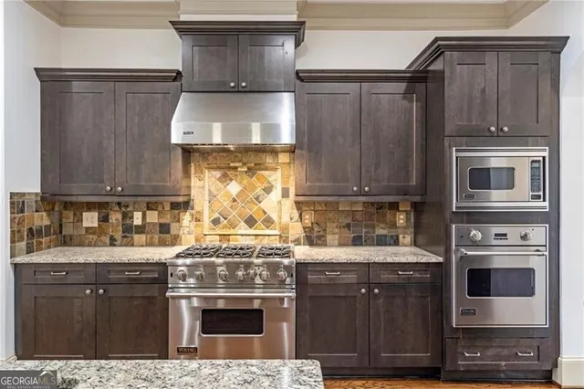 a kitchen with stainless steel appliances wooden cabinets and a stove top oven