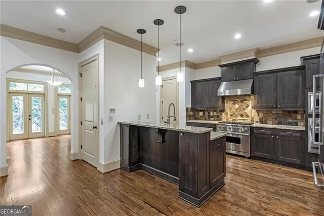 a kitchen with stainless steel appliances granite countertop wooden floors and sink