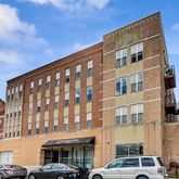 a front view of a building with lot of cars