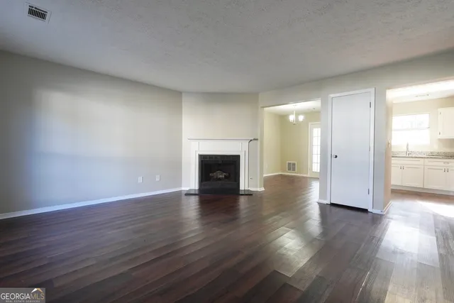 an empty room with wooden floor and fireplace