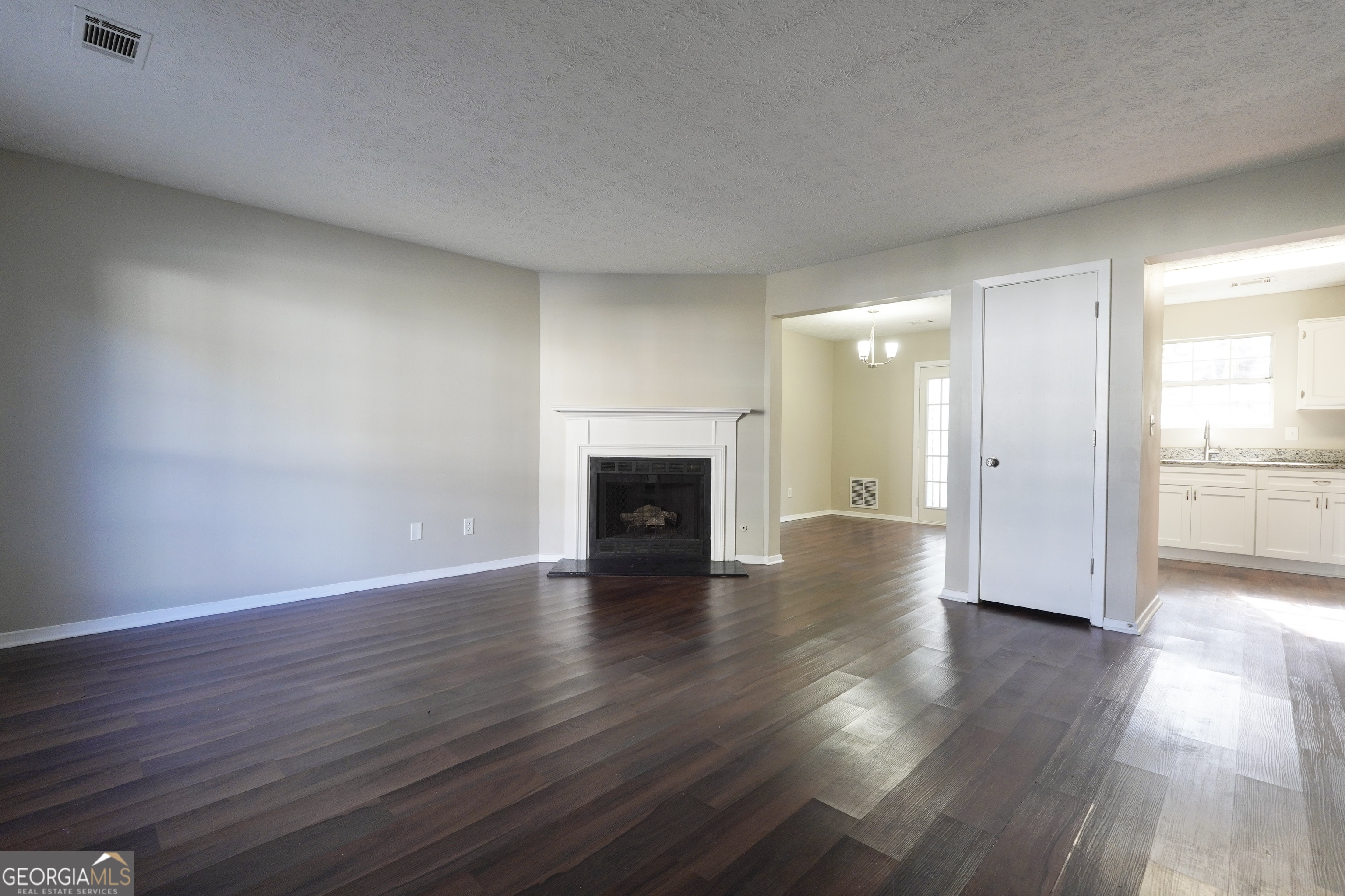 5702 Wells Circle Stone Mountain, GA 30087 - Photo 12 of 29 an empty room with wooden floor and fireplace
