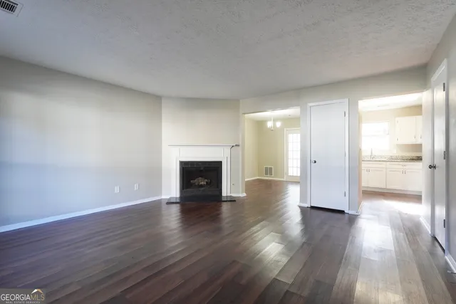 a view of empty room with wooden floor and fireplace