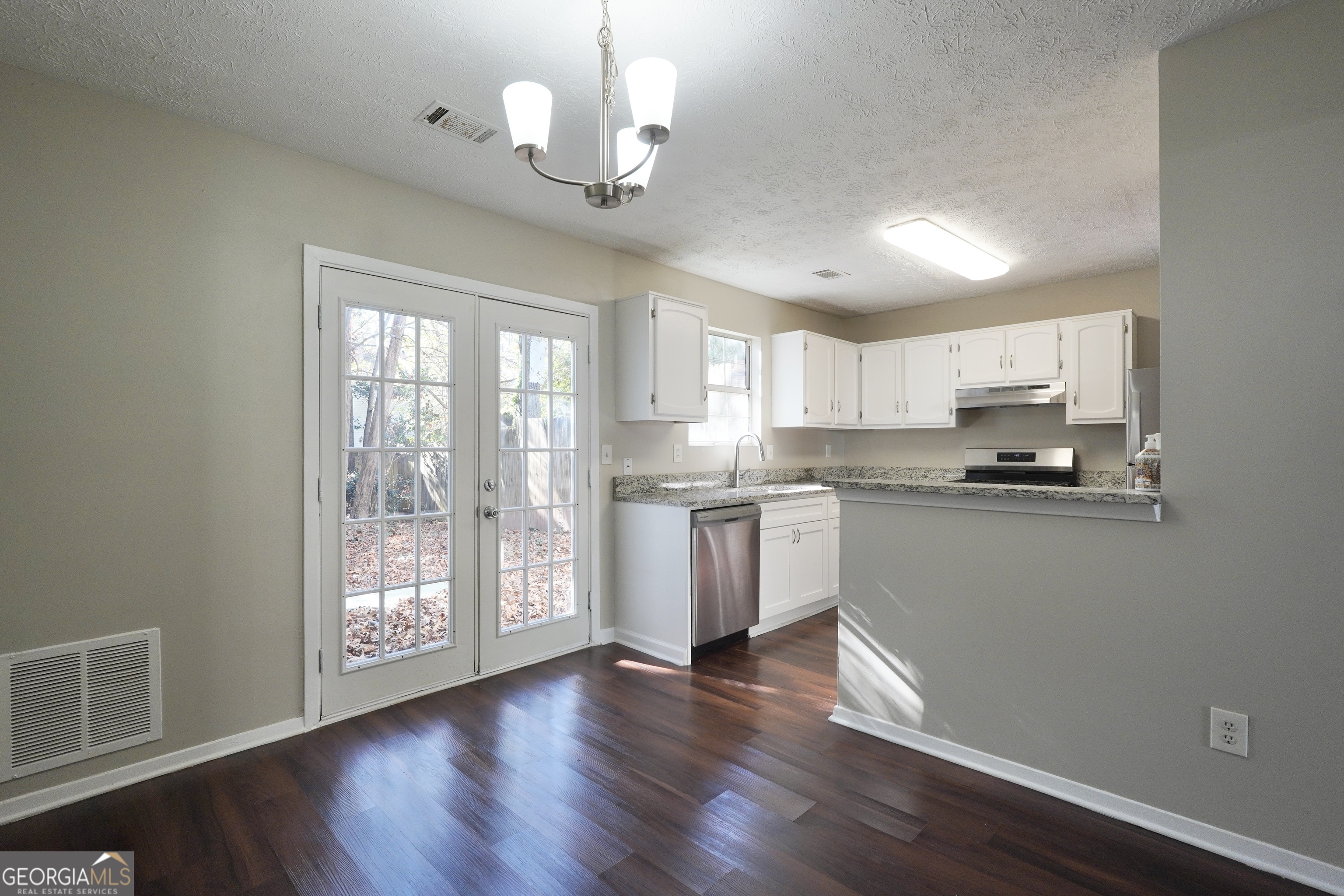 5702 Wells Circle Stone Mountain, GA 30087 - Photo 15 of 29 a kitchen with stainless steel appliances granite countertop a refrigerator a sink dishwasher a stove and white countertops with wooden floor