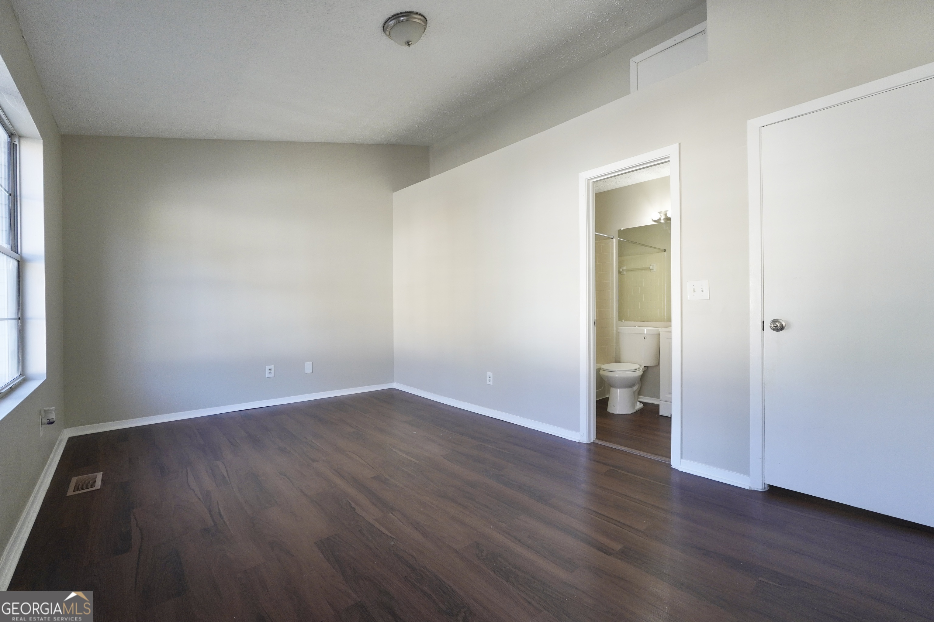 5702 Wells Circle Stone Mountain, GA 30087 - Photo 19 of 29 an empty room with wooden floor and windows