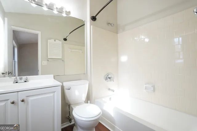 a bathroom with a sink toilet vanity and shower