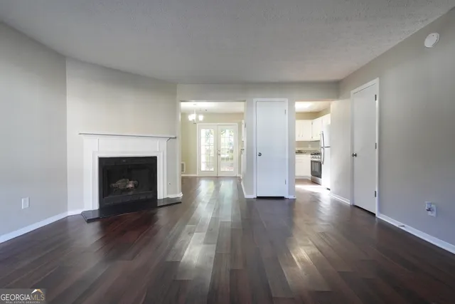 an empty room with wooden floor and a fireplace