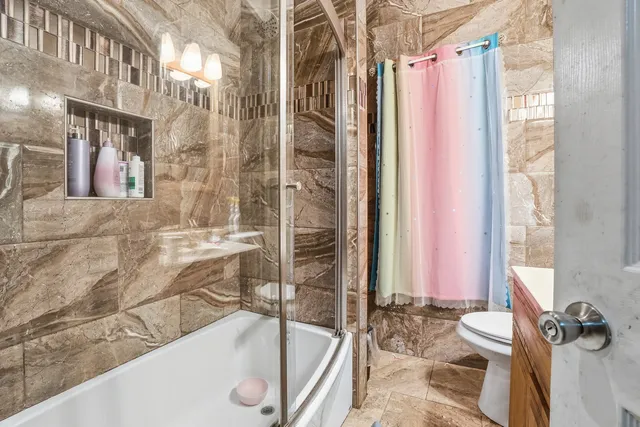 a bathroom with a granite countertop bathtub shower and a sink