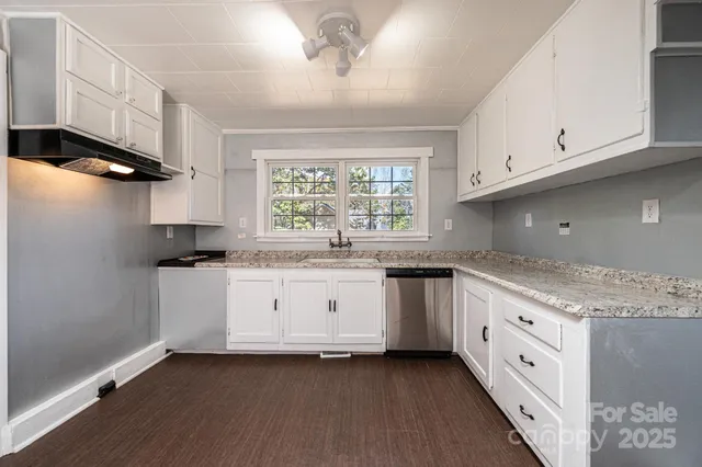 a kitchen with granite countertop a sink and a window