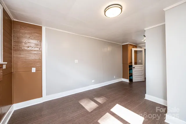 a view of an empty room with wooden floor