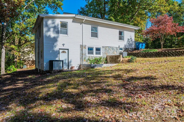 a view of a house with backyard and trees