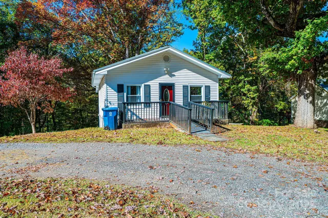 a front view of a house with a yard covered with trees