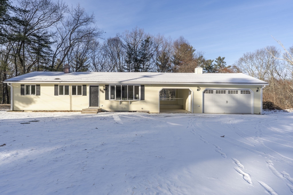 a view of a house with a yard and a large tree