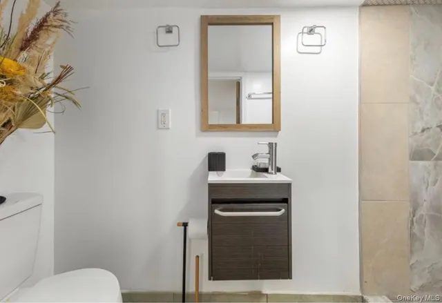 a bathroom with a toilet sink vanity and mirror