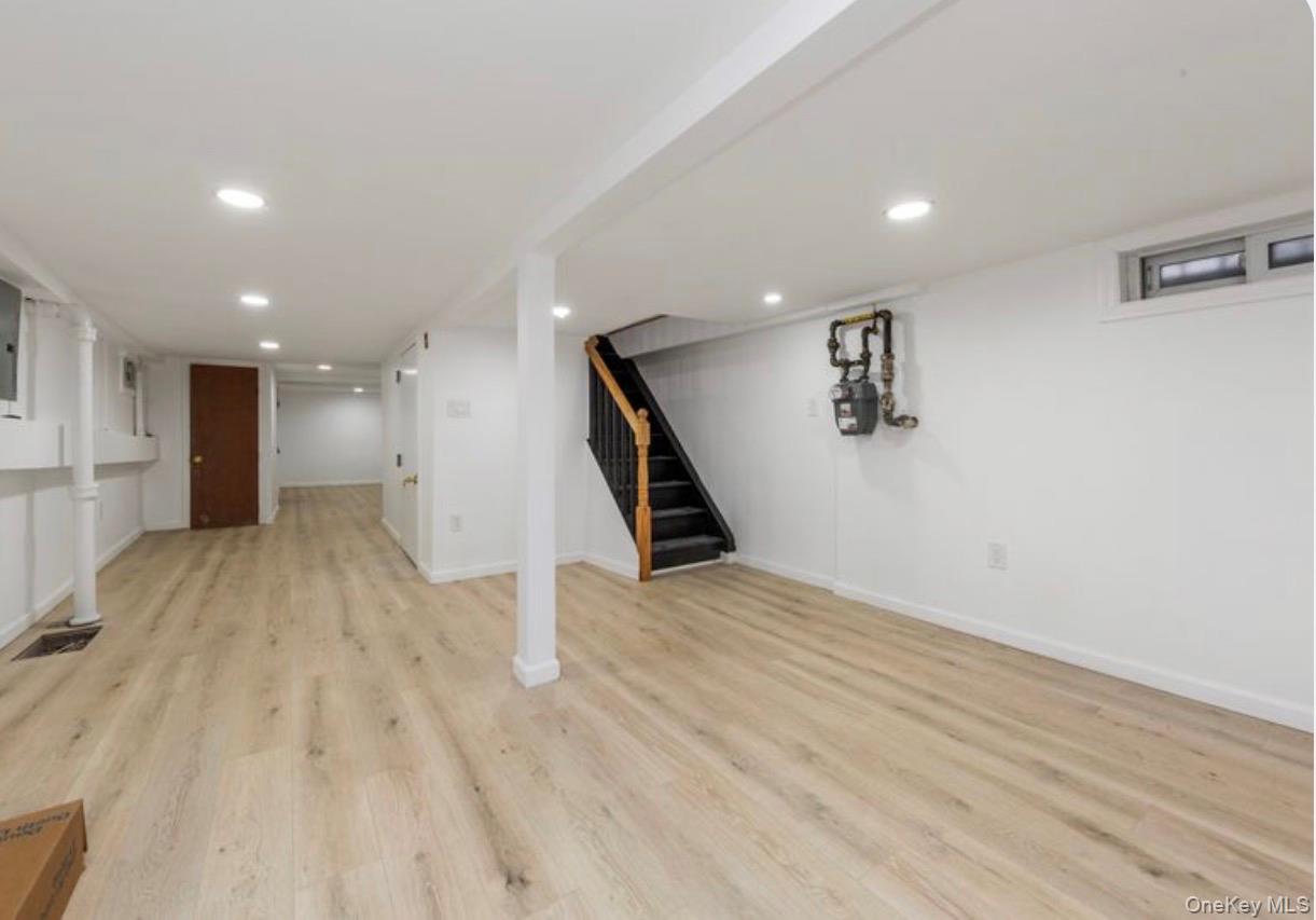 136-18 221st Street Queens, NY 11413 - Photo 19 of 23 Finished basement featuring stairs, light wood-style flooring, and recessed lighting