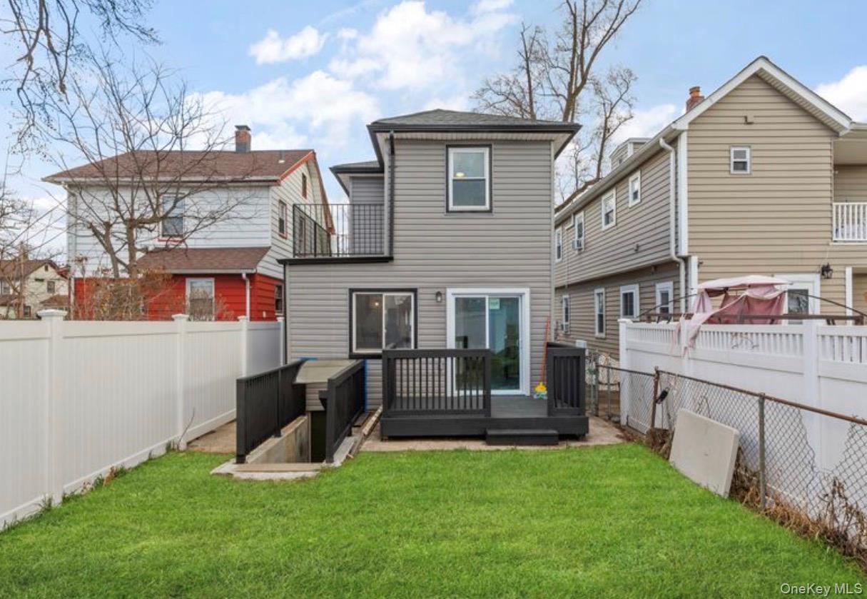 136-18 221st Street Queens, NY 11413 - Photo 22 of 23 Rear view of property featuring a fenced backyard, a wooden deck, and a balcony