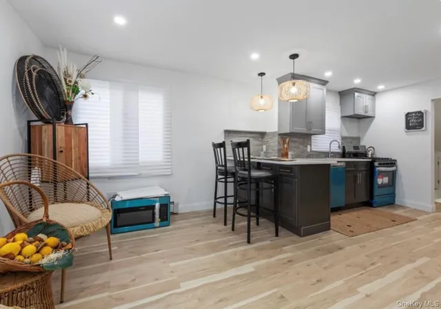 a kitchen with kitchen island granite countertop a stove a sink a dining table and chairs