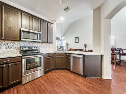 a kitchen with granite countertop wooden floors and stainless steel appliances