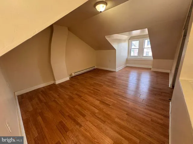 a view of a big room with wooden floor and windows