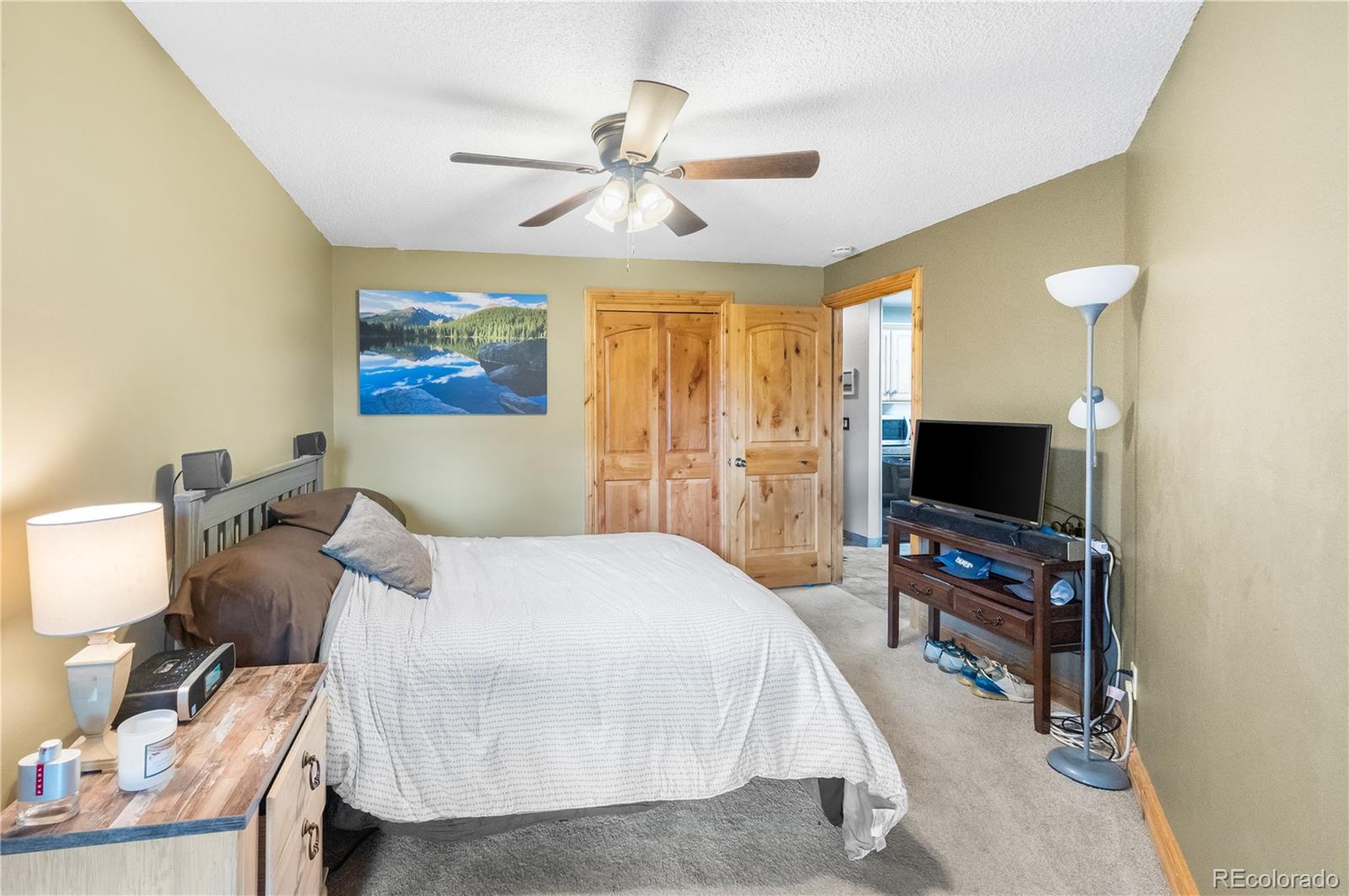 7222 Ryan Gulch Road, Unit 202 Silverthorne, CO 80498 - Photo 17 of 36 a bedroom with a bed and a flat screen tv