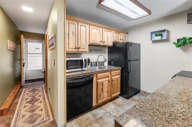 a kitchen with stainless steel appliances granite countertop a refrigerator stove and sink