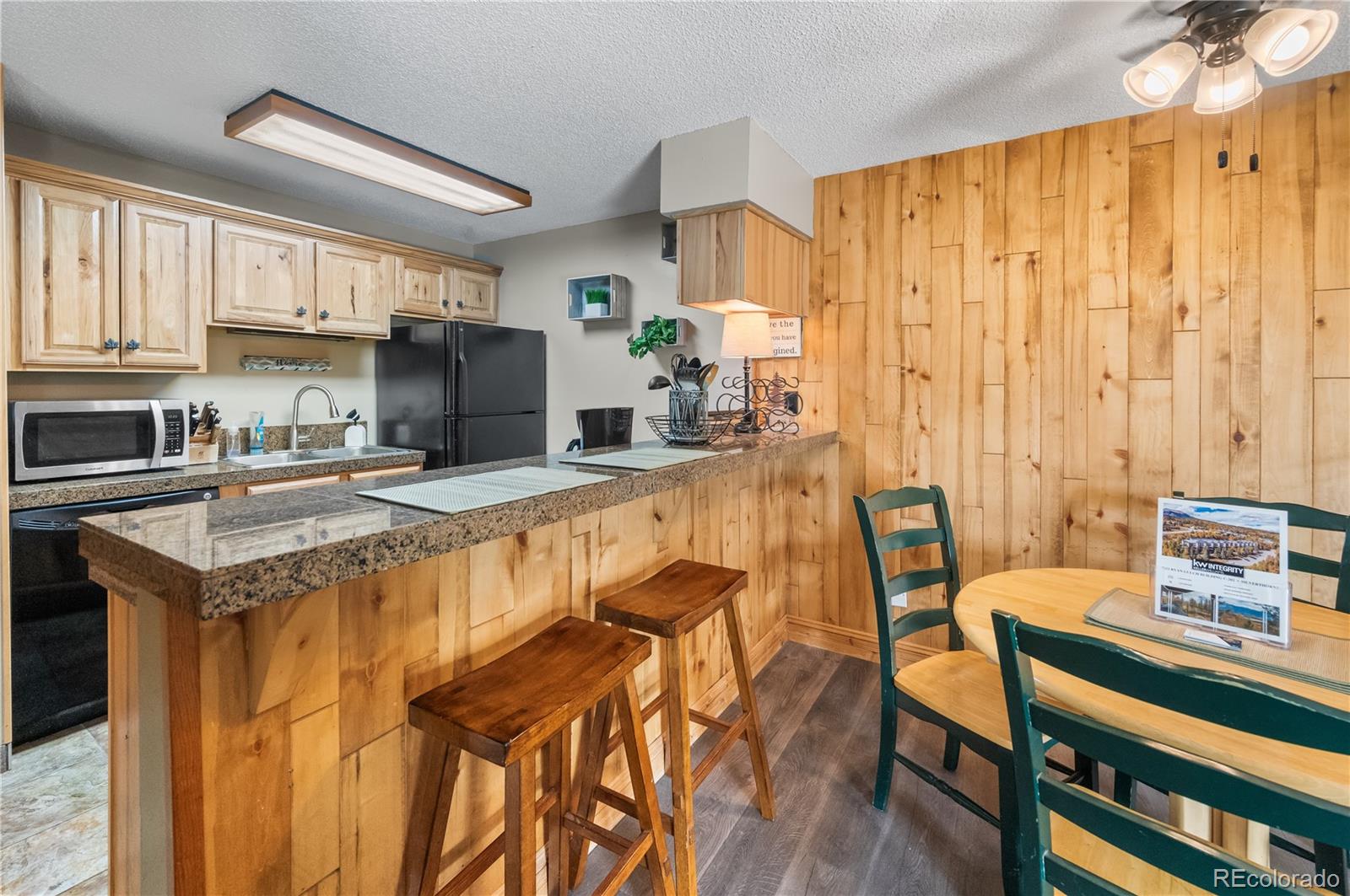 7222 Ryan Gulch Road, Unit 202 Silverthorne, CO 80498 - Photo 8 of 36 a kitchen with a table chairs stove and cabinets