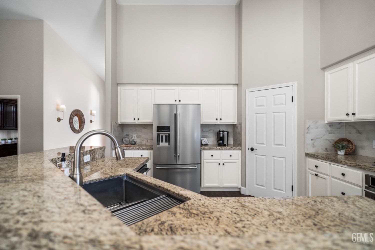 Undisclosed Address Bakersfield, CA 93308 - Photo 14 of 37 a kitchen with stainless steel appliances kitchen island a refrigerator sink and cabinets