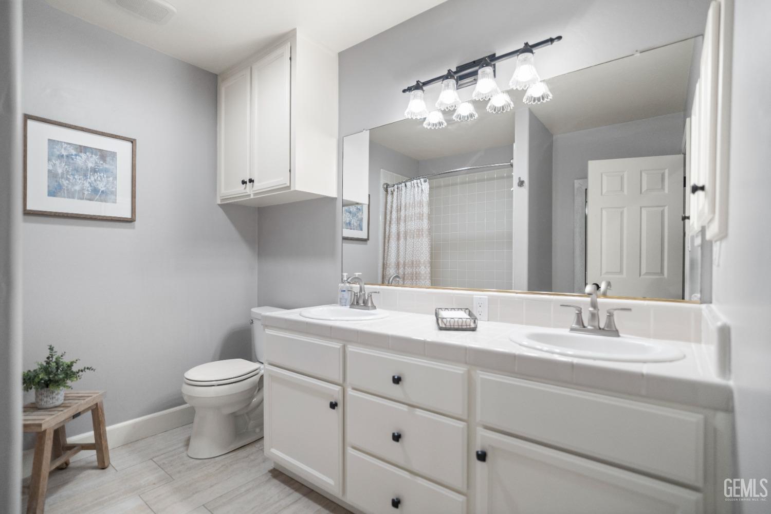 Undisclosed Address Bakersfield, CA 93308 - Photo 22 of 37 a bathroom with a toilet a sink and mirror