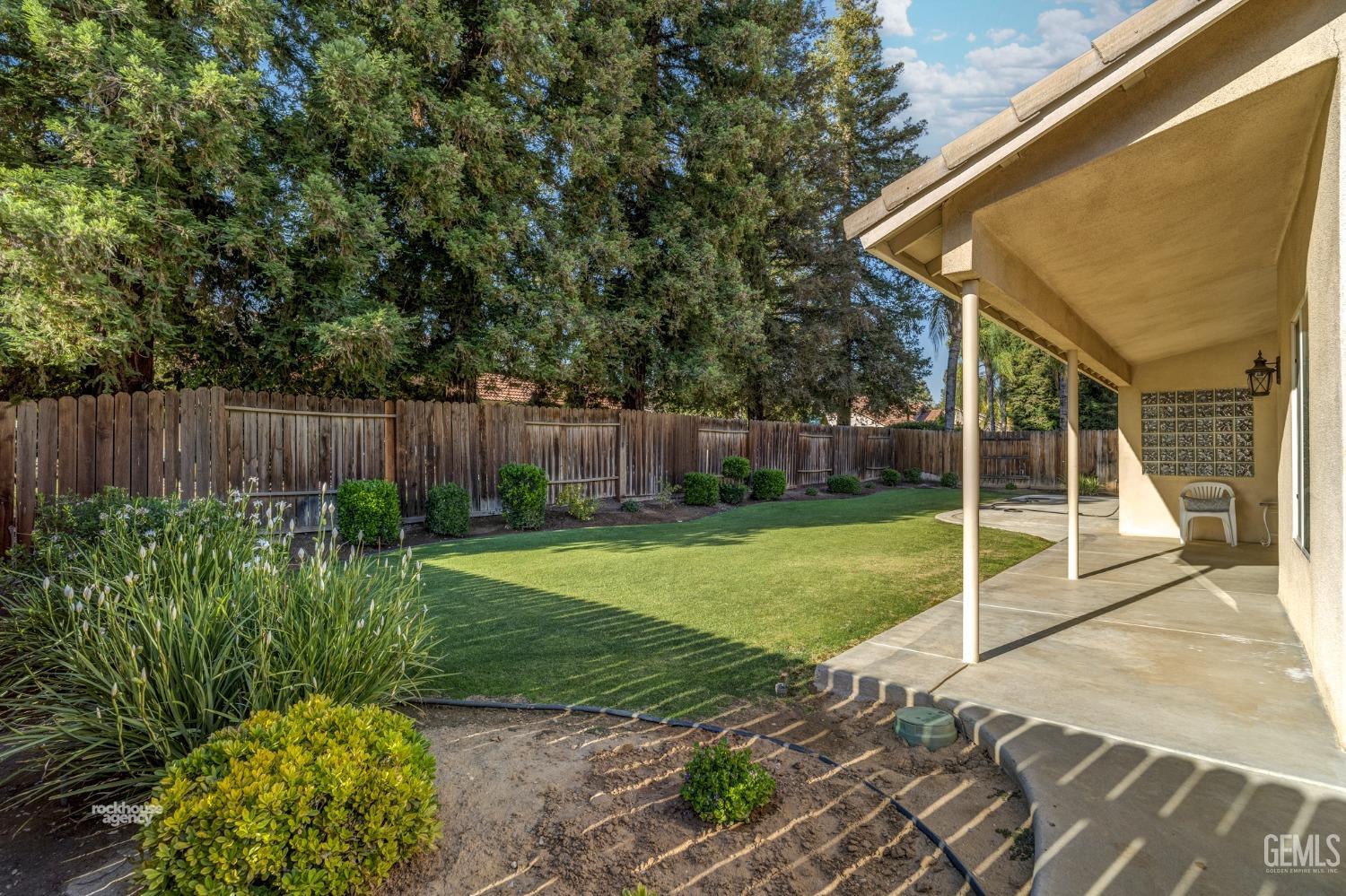 Undisclosed Address Bakersfield, CA 93308 - Photo 33 of 37 a view of a backyard with table and chairs and wooden fence