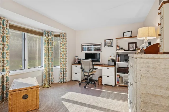 a view of a workspace with furniture and a window
