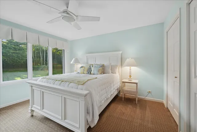 a bed sitting in a spacious bedroom next to a window